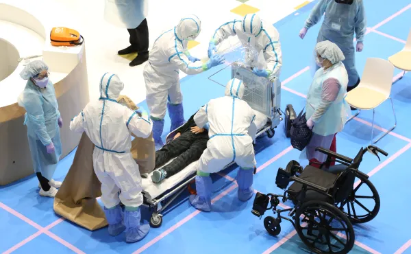 防護服で全身を包み、受け入れ対応にあたる職員たち